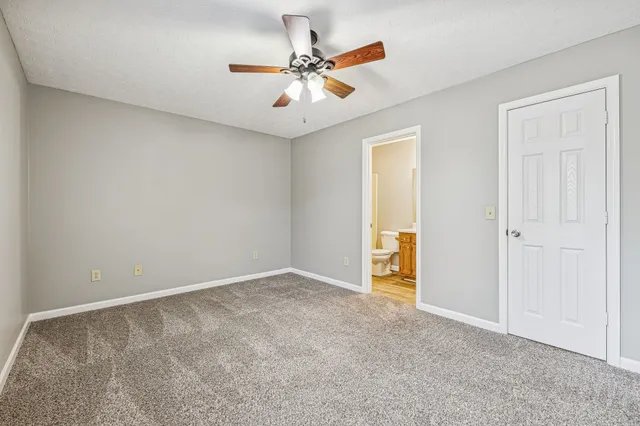 an empty room with closet and ceiling fan