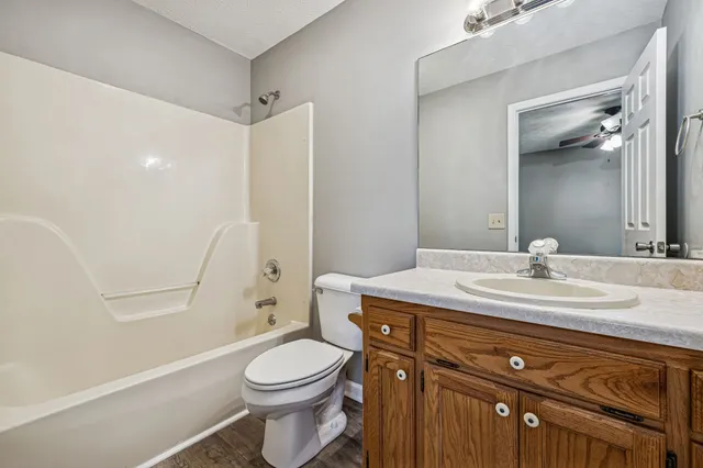 a bathroom with a granite countertop toilet sink and mirror