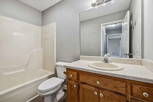a bathroom with a granite countertop sink toilet a mirror and shower