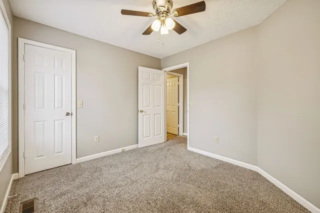 an empty room with fan and windows