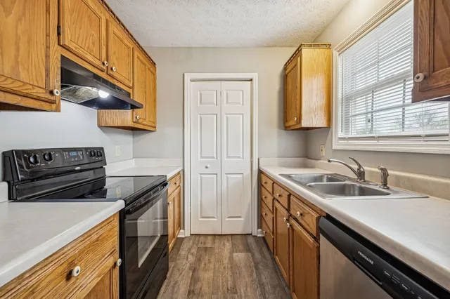 a kitchen with a sink stove top oven and cabinets