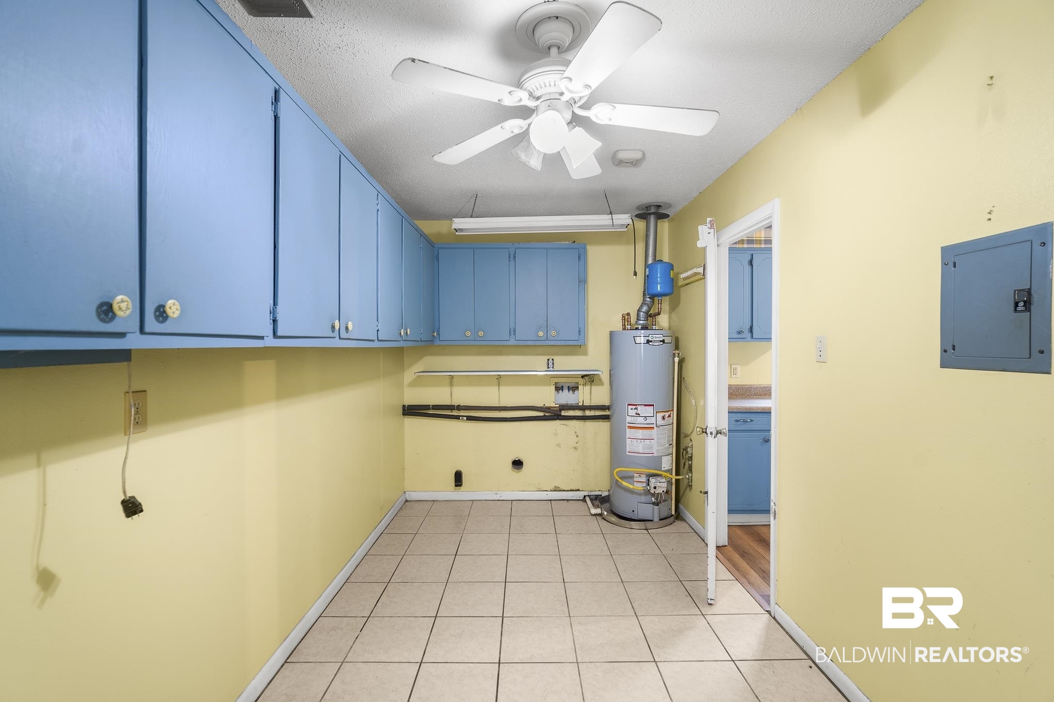 2710 Longleaf Drive Mobile, AL 36693 - Photo 19 of 27 Kitchen with blue cabinets, ceiling fan, gas water heater, and light tile floors