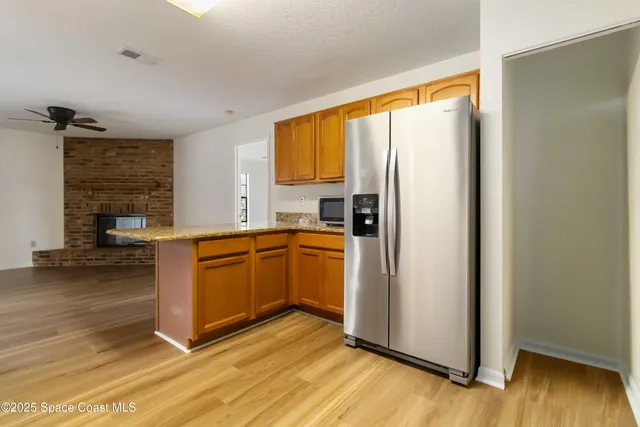 a kitchen with stainless steel appliances granite countertop a refrigerator a sink and a stove