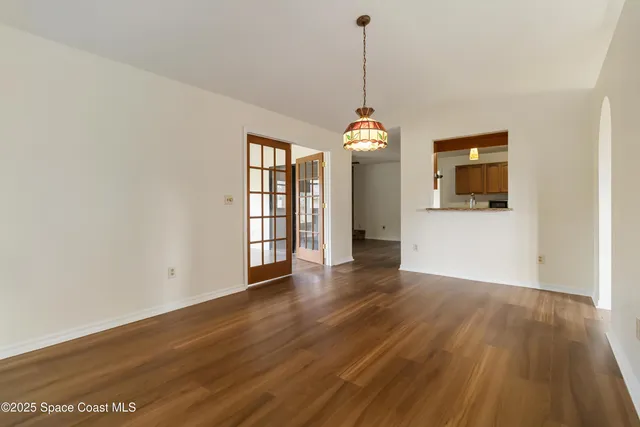 a view of a room with wooden floor and entryway