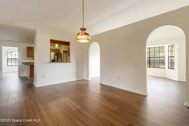 a view of a room with wooden floor windows and a kitchen