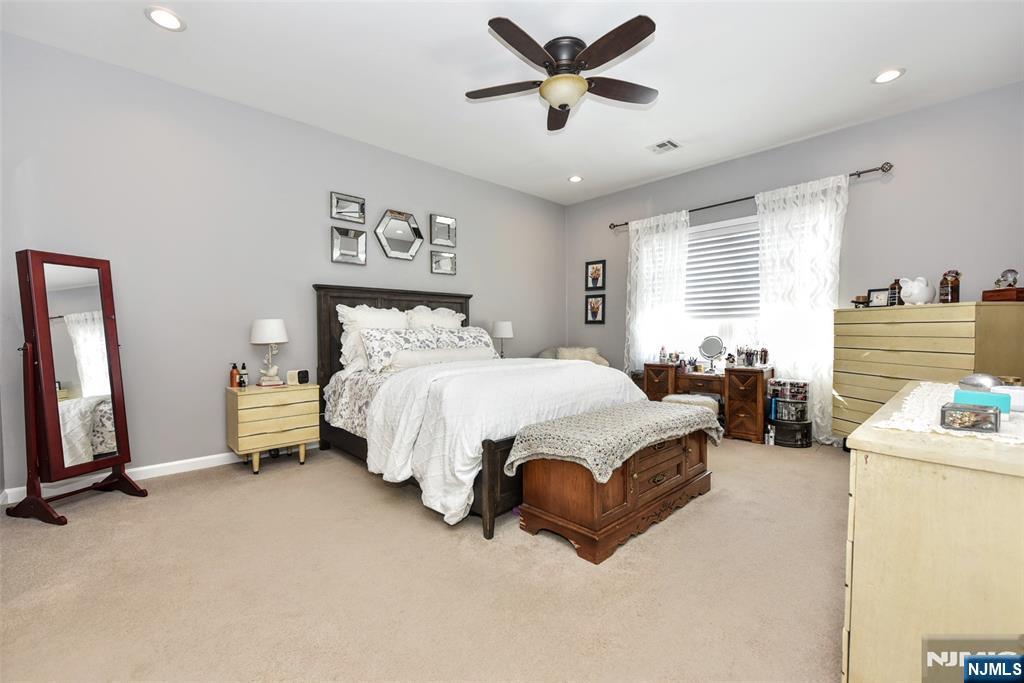 130 Reich Avenue Mahwah, NJ 07430 - Photo 16 of 30 a bedroom with a bed and a chandelier