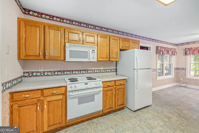 a kitchen with a refrigerator sink stove and cabinets