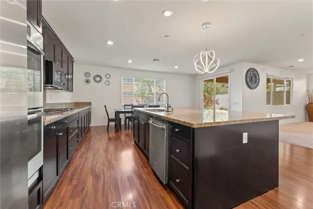 a kitchen with stainless steel appliances granite countertop a stove and a wooden floors