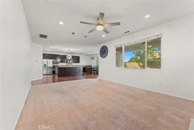 an empty room with kitchen and windows