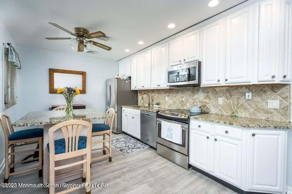 a kitchen with stainless steel appliances granite countertop a stove and white cabinets