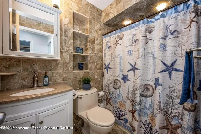 a bathroom with a toilet sink and mirror