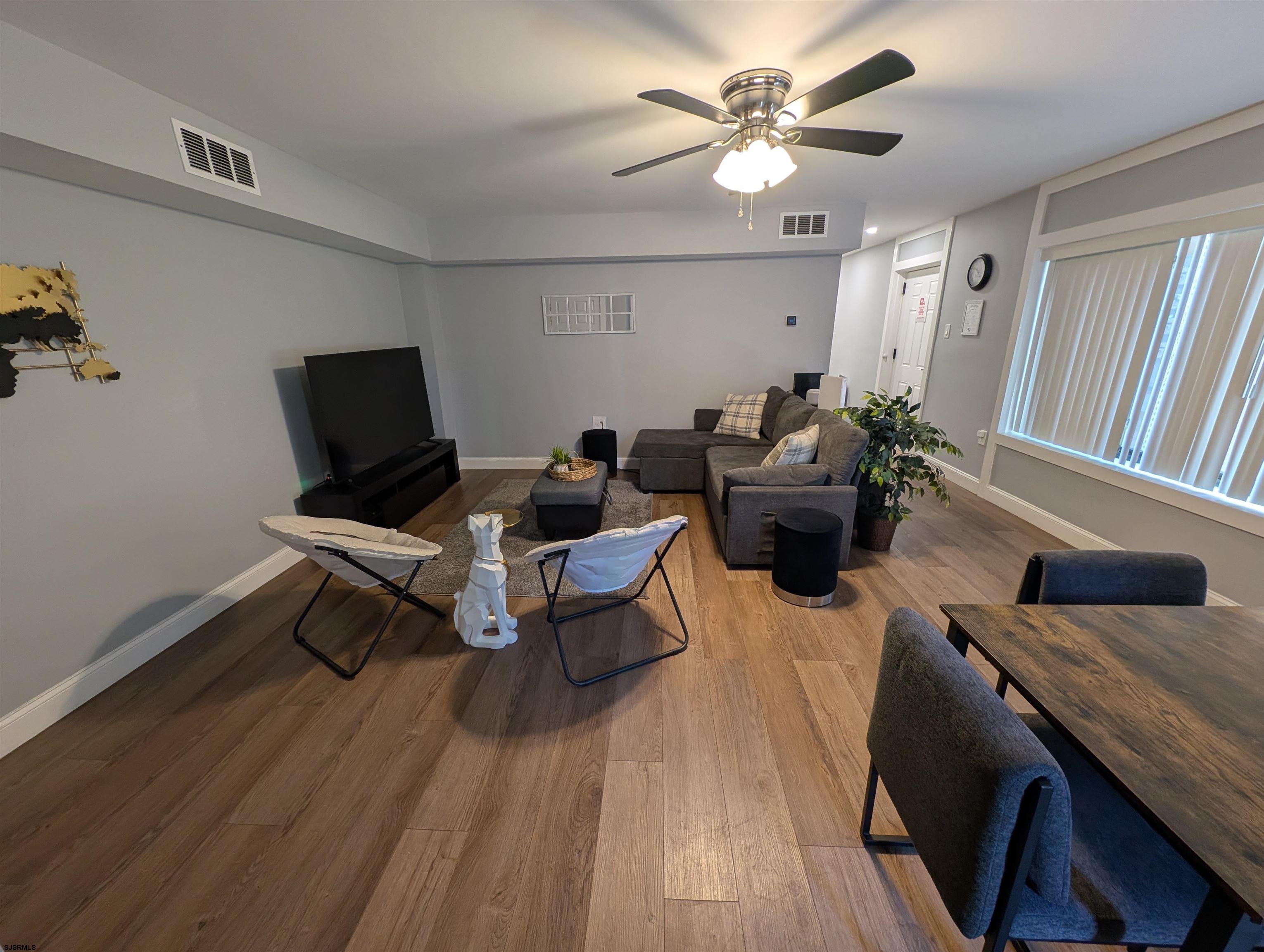 600 Pacific Avenue, Unit D102 Atlantic City, NJ 08401 - Photo 14 of 35 a living room with furniture a chandelier and a wooden floor