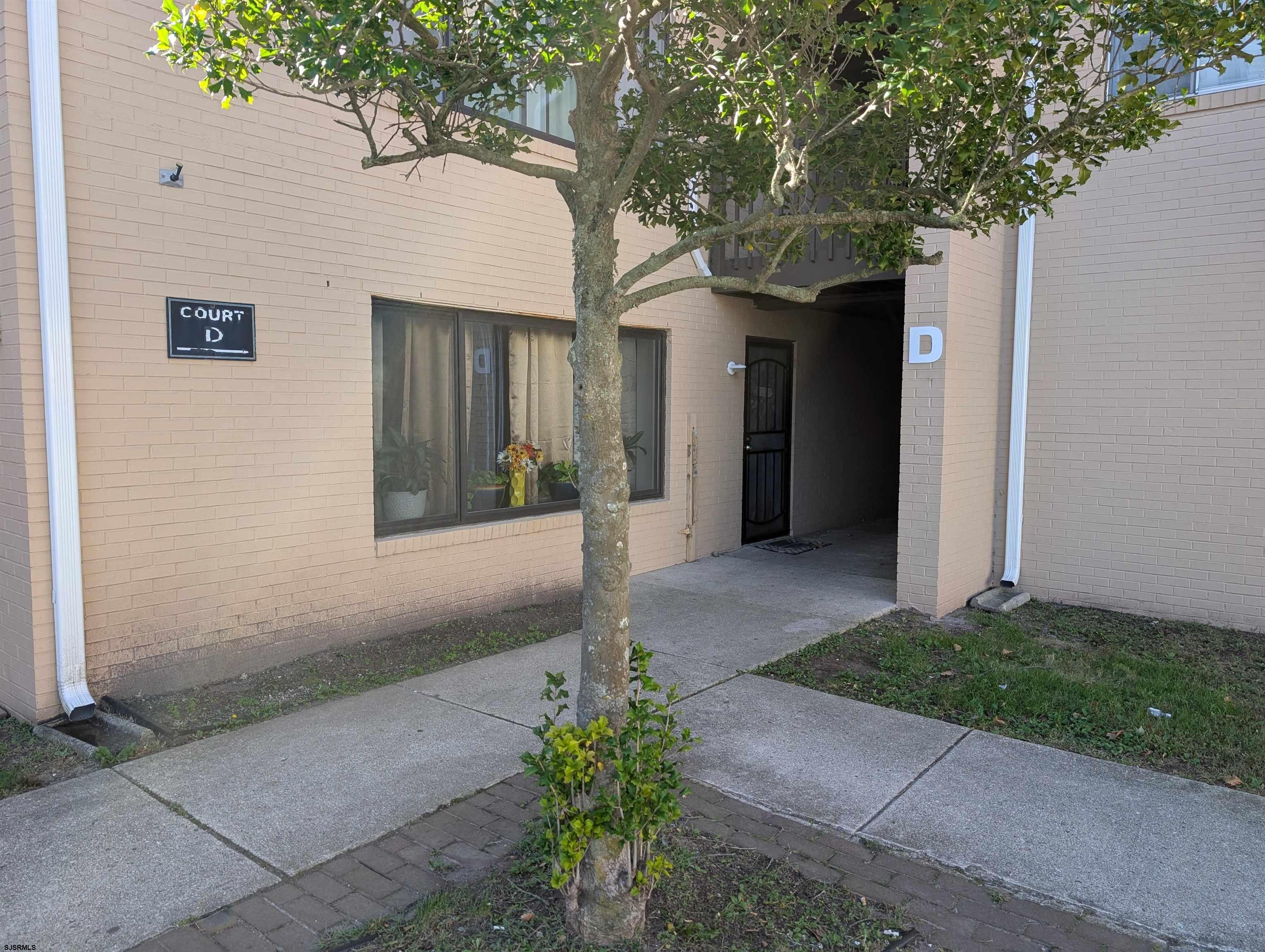 600 Pacific Avenue, Unit D102 Atlantic City, NJ 08401 - Photo 2 of 35 a front view of a house with a yard and garage