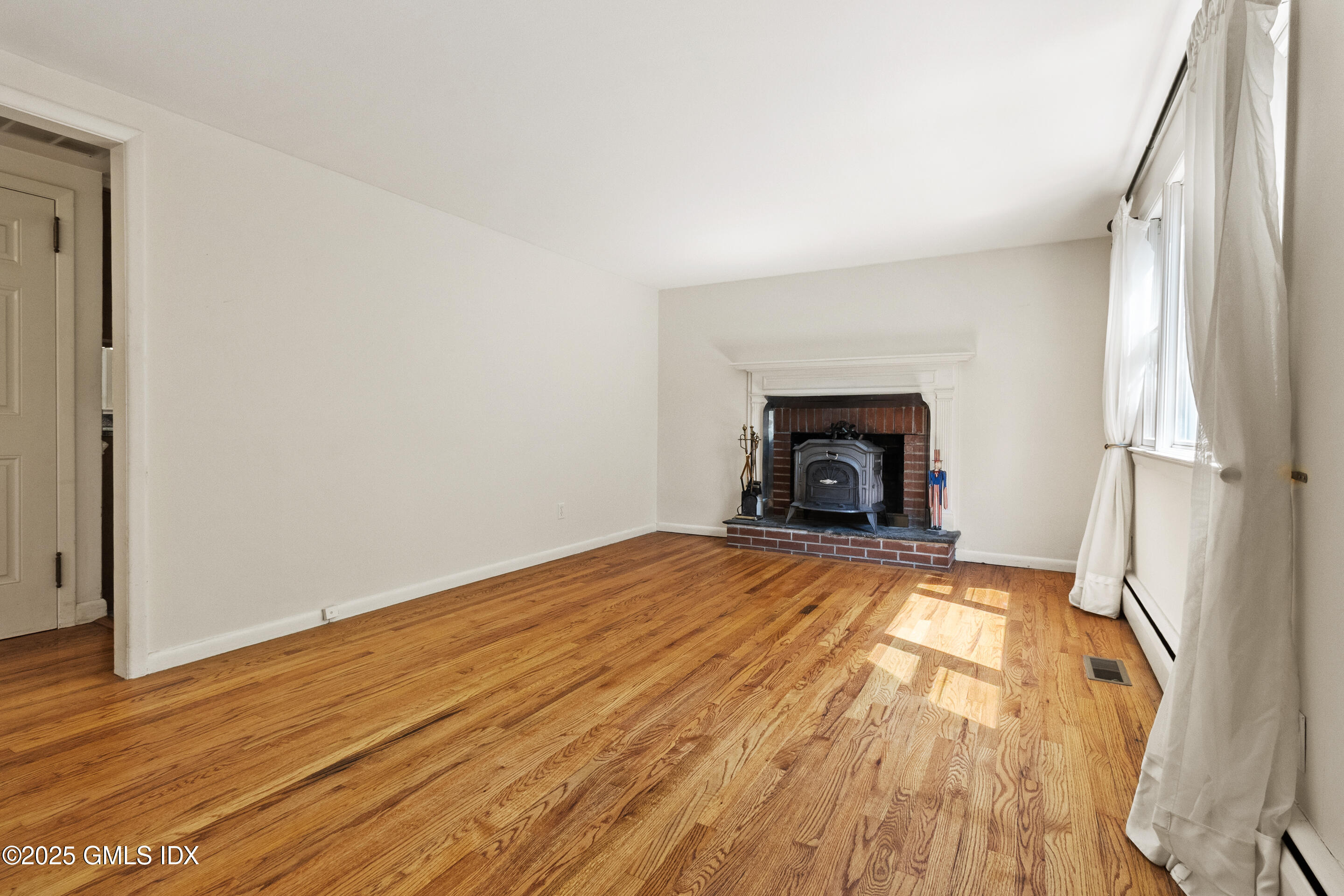 17 Cornwall Road Norwalk, CT 06850 - Photo 8 of 28 a view of empty room with wooden floor and fireplace
