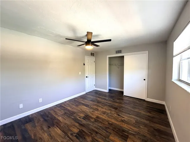 a view of a room with wooden floor and a ceiling fan