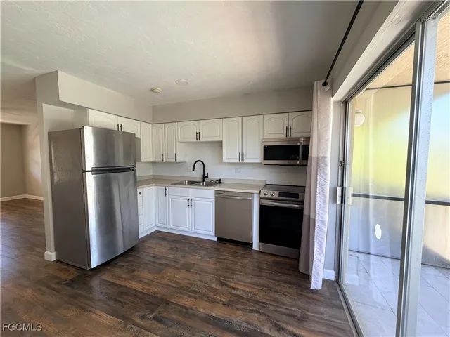 a kitchen with stainless steel appliances a refrigerator sink and microwave