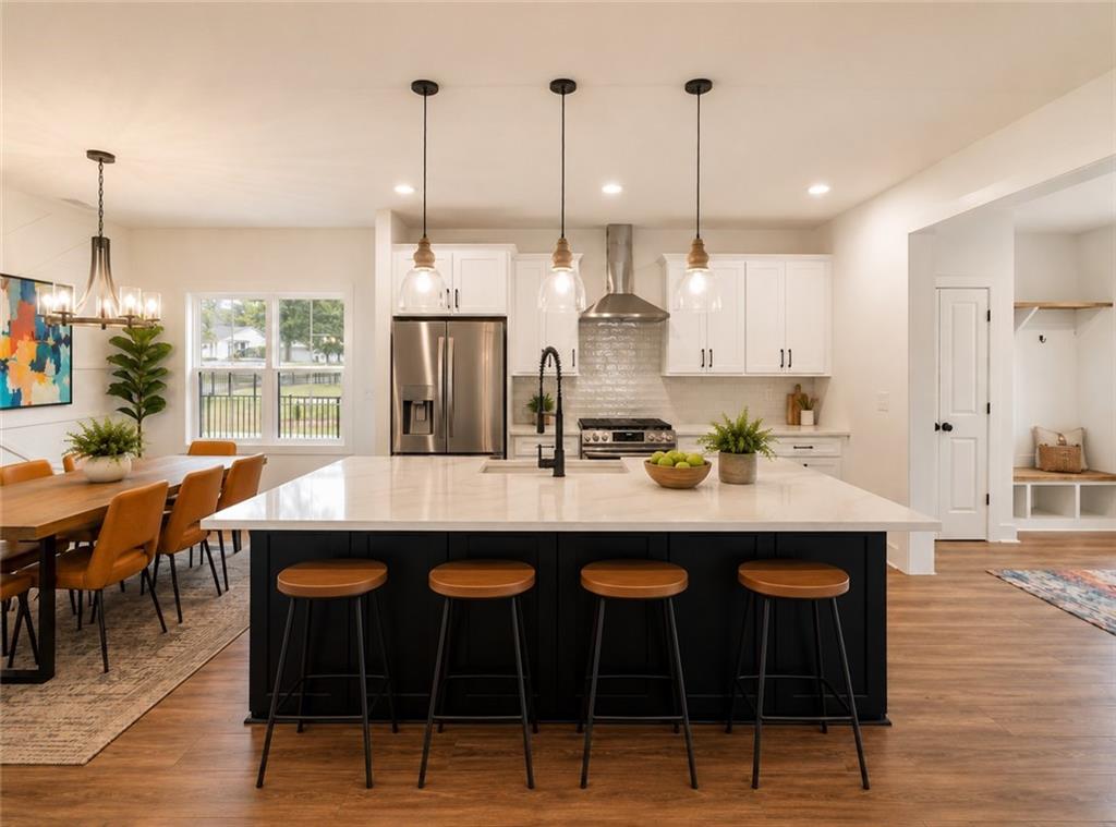 131 Old Alabama Road Southeast Emerson, GA 30137 - Photo 11 of 44 a kitchen with kitchen island stainless steel appliances a table chairs sink and wooden floor