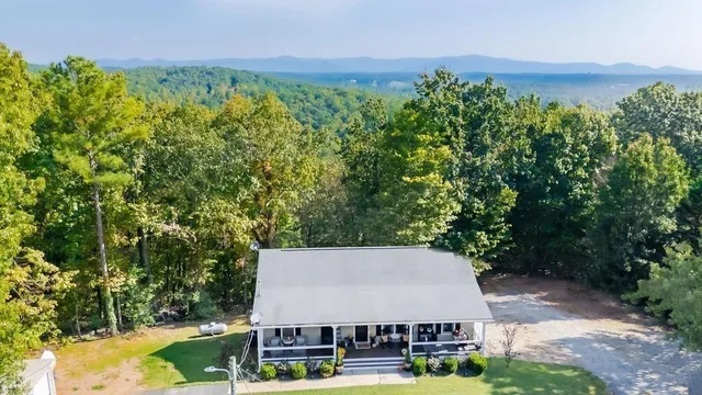an aerial view of a house with swimming pool and garden