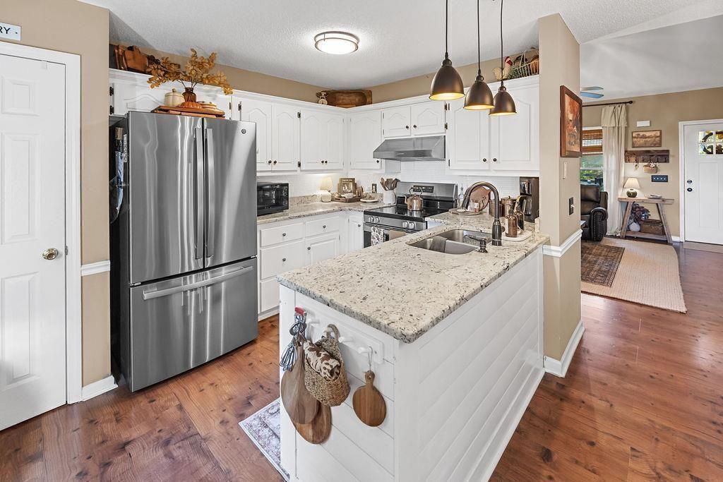 603 Cutoff Road Jasper, GA 30143 - Photo 11 of 24 a kitchen with stainless steel appliances granite countertop a refrigerator a stove a sink dishwasher and a refrigerator with wooden floor
