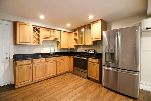a kitchen with stainless steel appliances granite countertop a refrigerator sink and cabinets