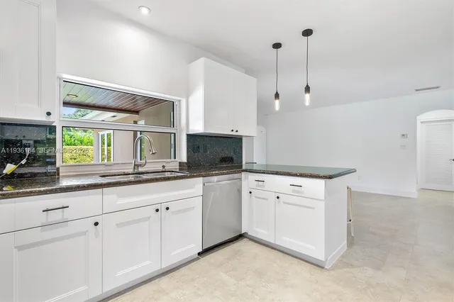 a kitchen with white cabinets and white appliances