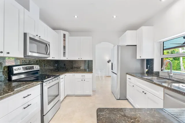 a kitchen with stainless steel appliances granite countertop a sink and a stove
