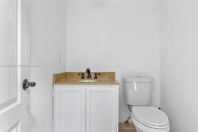 a bathroom with a granite countertop toilet sink and mirror