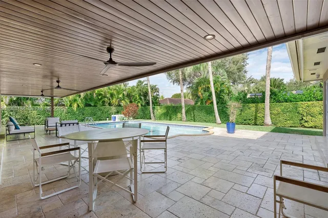 a view of a patio with a table chairs and a backyard