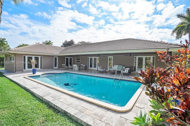 a view of house with swimming pool and furniture