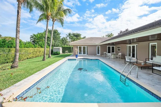 a view of a house with a yard patio and swimming pool