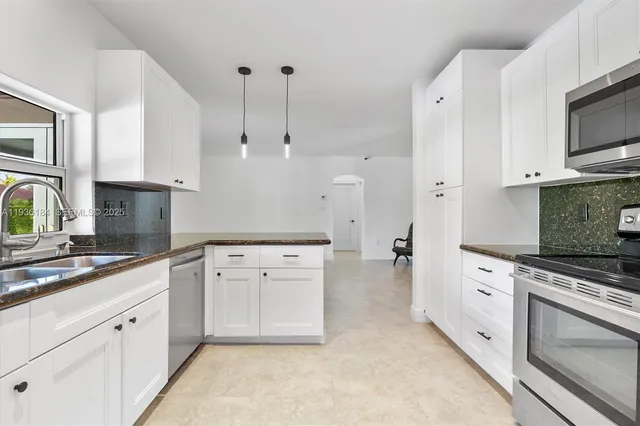 a kitchen with white cabinets and white appliances