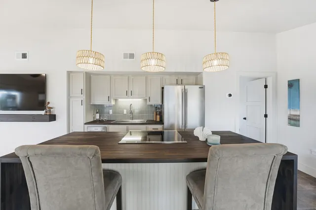 a kitchen with stainless steel appliances granite countertop a sink a refrigerator and a stove