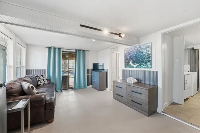 a living room with furniture and large windows