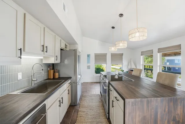 a kitchen with granite countertop a sink a counter top space appliances and cabinets