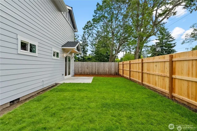 a view of a backyard with wooden fence