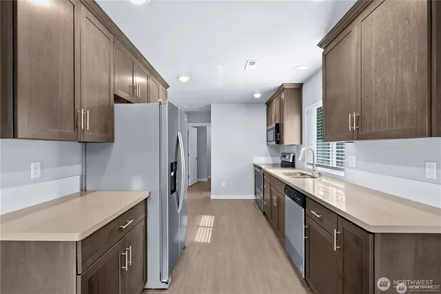 a kitchen with stainless steel appliances granite countertop a sink stove and refrigerator