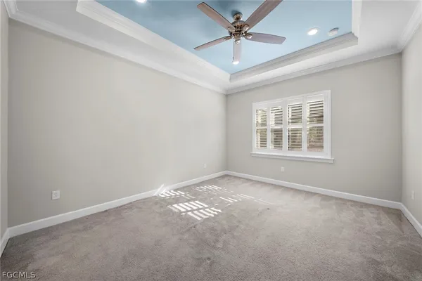 an empty room with a window and ceiling fan
