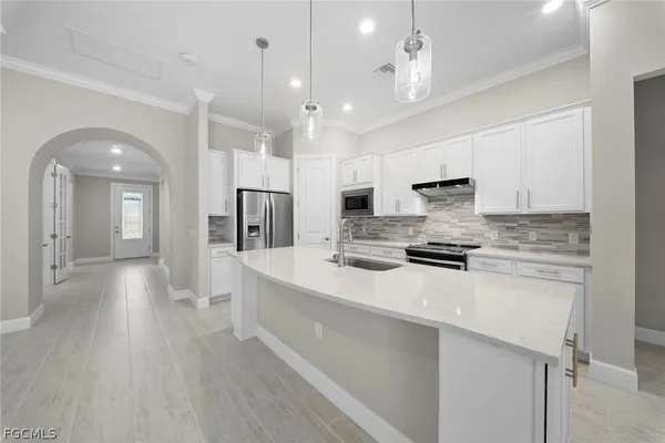 a large kitchen with kitchen island a sink stainless steel appliances and cabinets