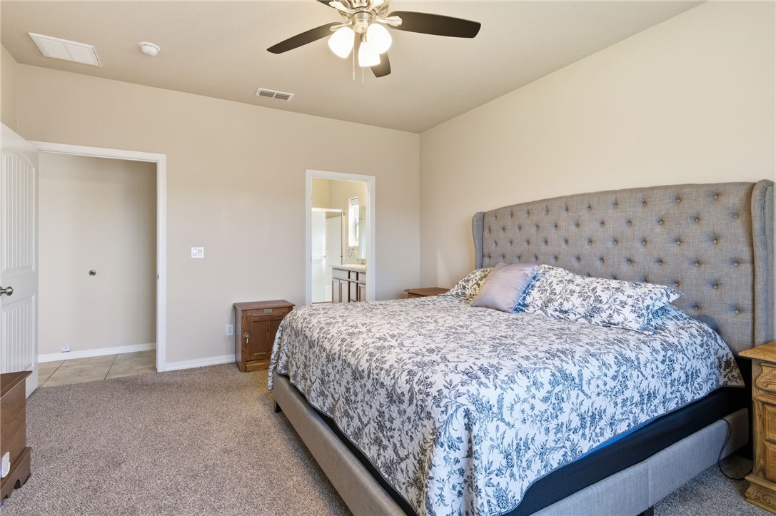 4745 East Old W Road Kingman, AZ 86401 - Photo 16 of 37 Bedroom featuring light carpet, a ceiling fan, and ensuite bathroom