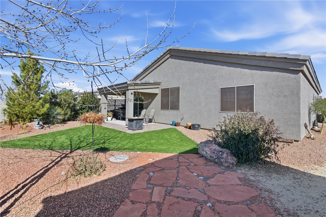 4745 East Old W Road Kingman, AZ 86401 - Photo 27 of 37 Rear view of house featuring a patio area, stucco siding, and a lawn