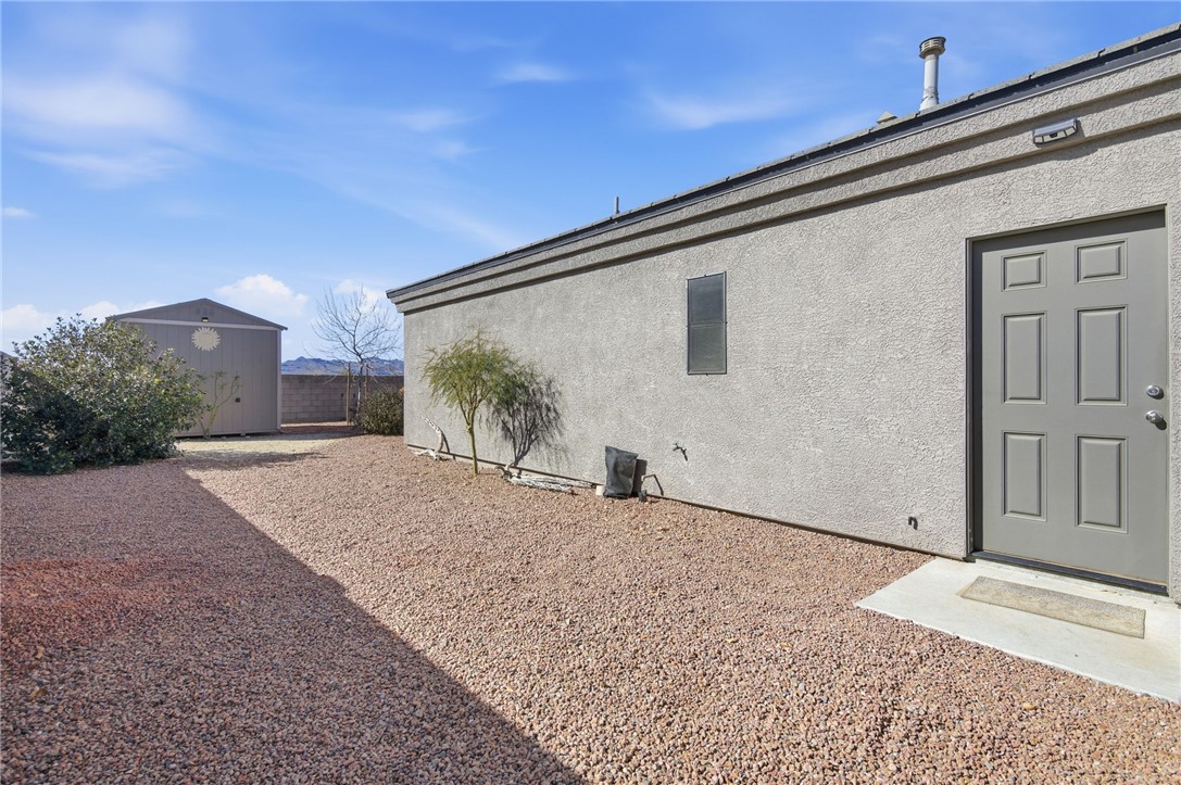 4745 East Old W Road Kingman, AZ 86401 - Photo 36 of 37 View of side of property with stucco siding and an outdoor structure