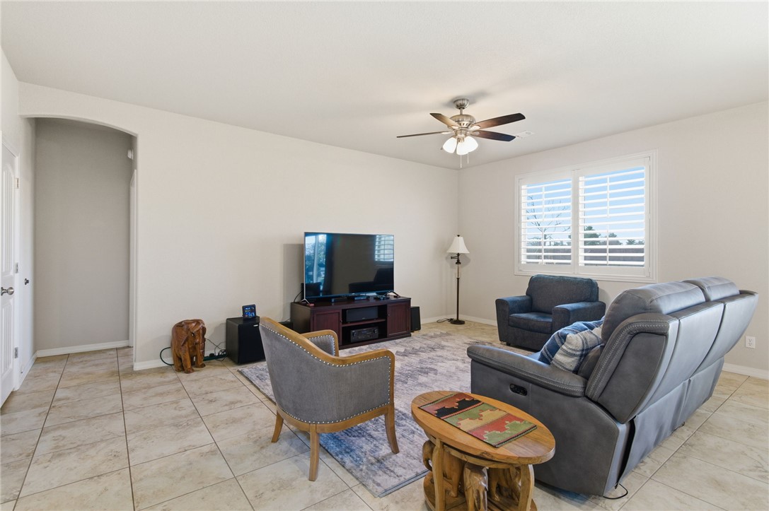 4745 East Old W Road Kingman, AZ 86401 - Photo 7 of 37 Living room with arched walkways, a ceiling fan, and light tile patterned flooring