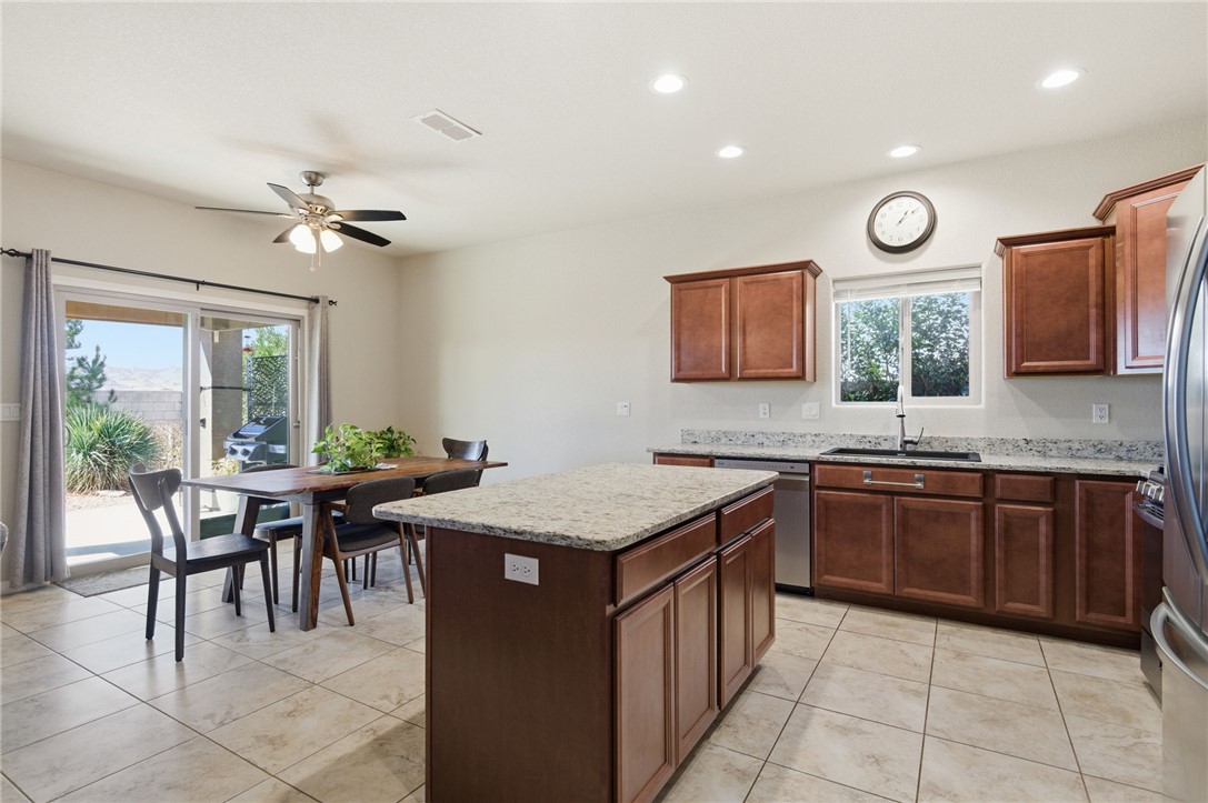 4745 East Old W Road Kingman, AZ 86401 - Photo 9 of 37 Kitchen with light stone counters, a kitchen island, light tile patterned floors, ceiling fan, and stainless steel appliances