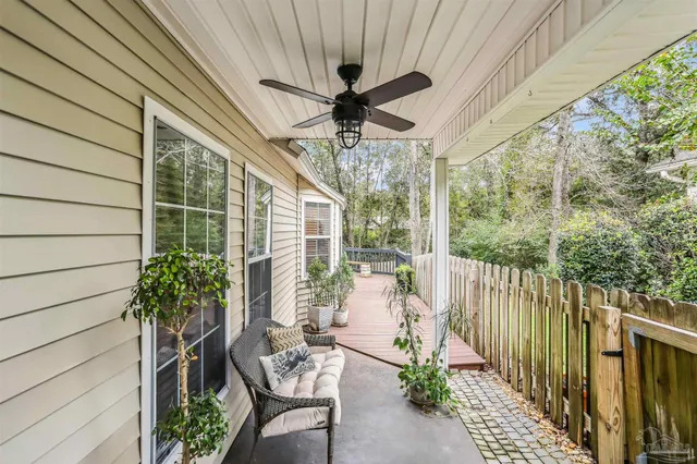 a roof deck with table and chairs and potted plants with wooden floor