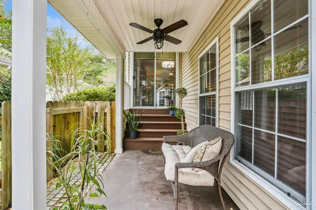a view of a porch with chairs and potted plants
