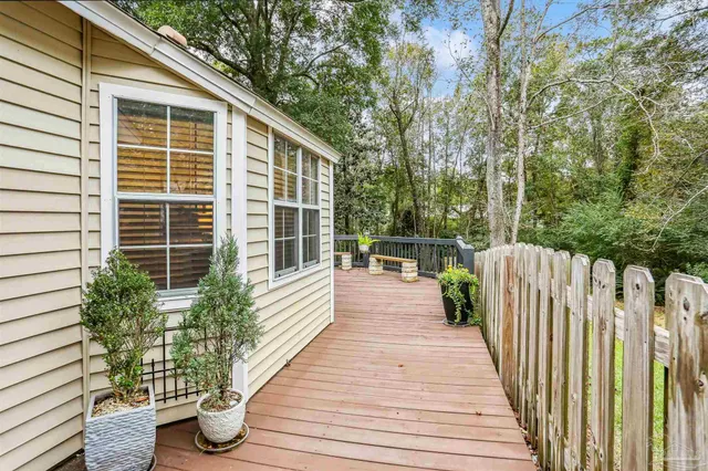 a view of balcony with wooden floor and fence