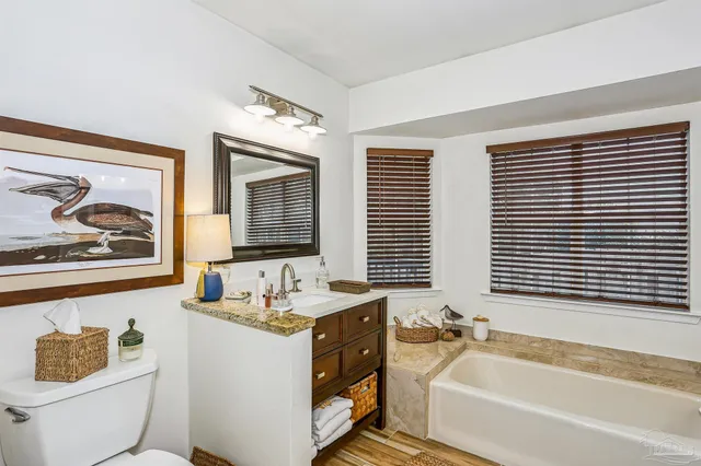 a bathroom with a granite countertop tub a sink and a window