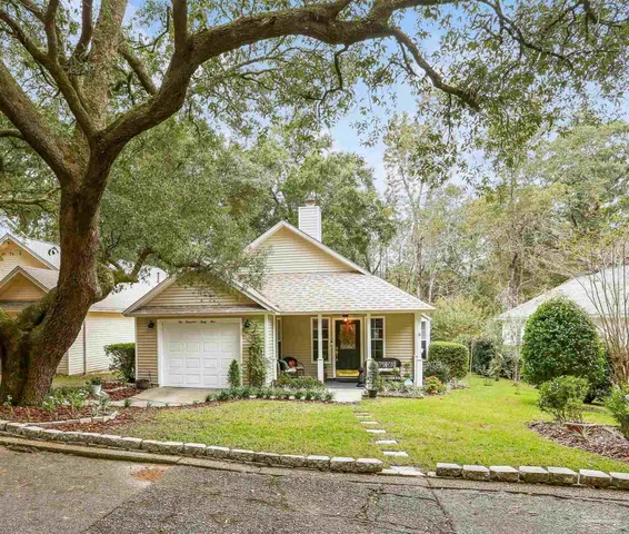 a front view of a house with a garden and trees