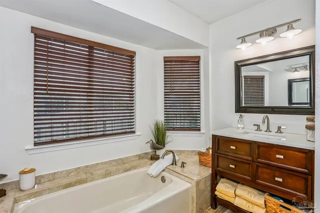 a bathroom with a granite countertop sink and a large mirror