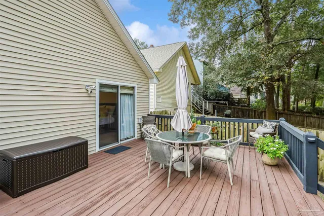 a balcony with wooden floor table and chairs